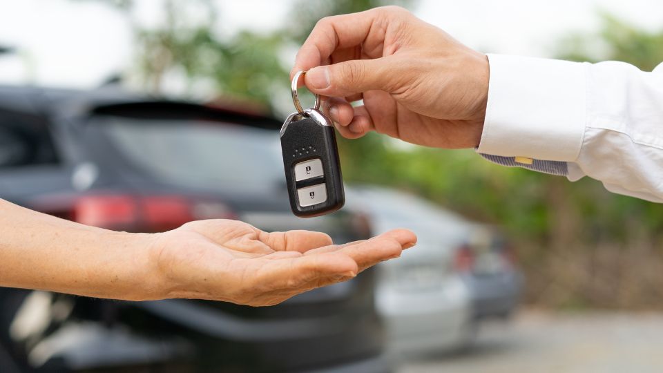 a person handing a key over to someone a person handing a key over to someone