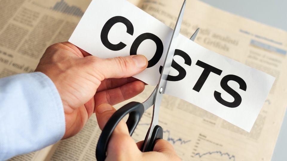 cost saving a person cutting a paper printed with costs