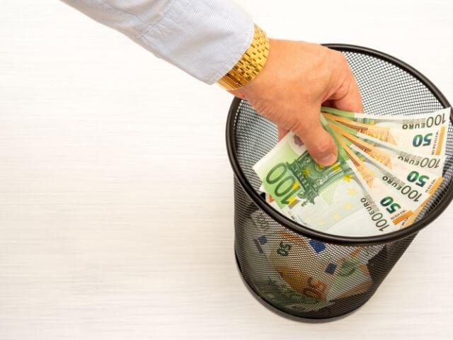 a person throwing money into a bin