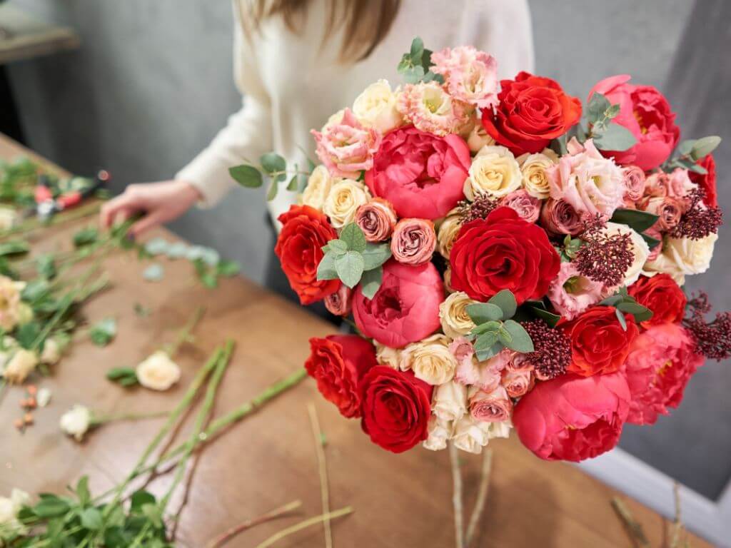 Florist creates beautiful rose bouquet of mixed flowers