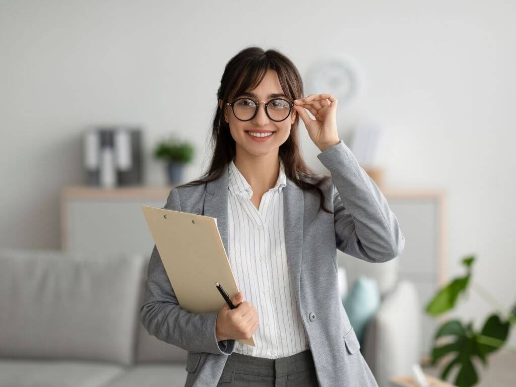 a happy psychologist holding her file, ready for her next appointment