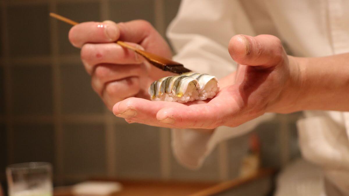 a japanese chef patiently preparing sushis