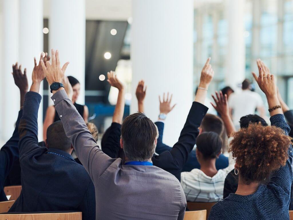 participants raising hands to ask questions in a workshop